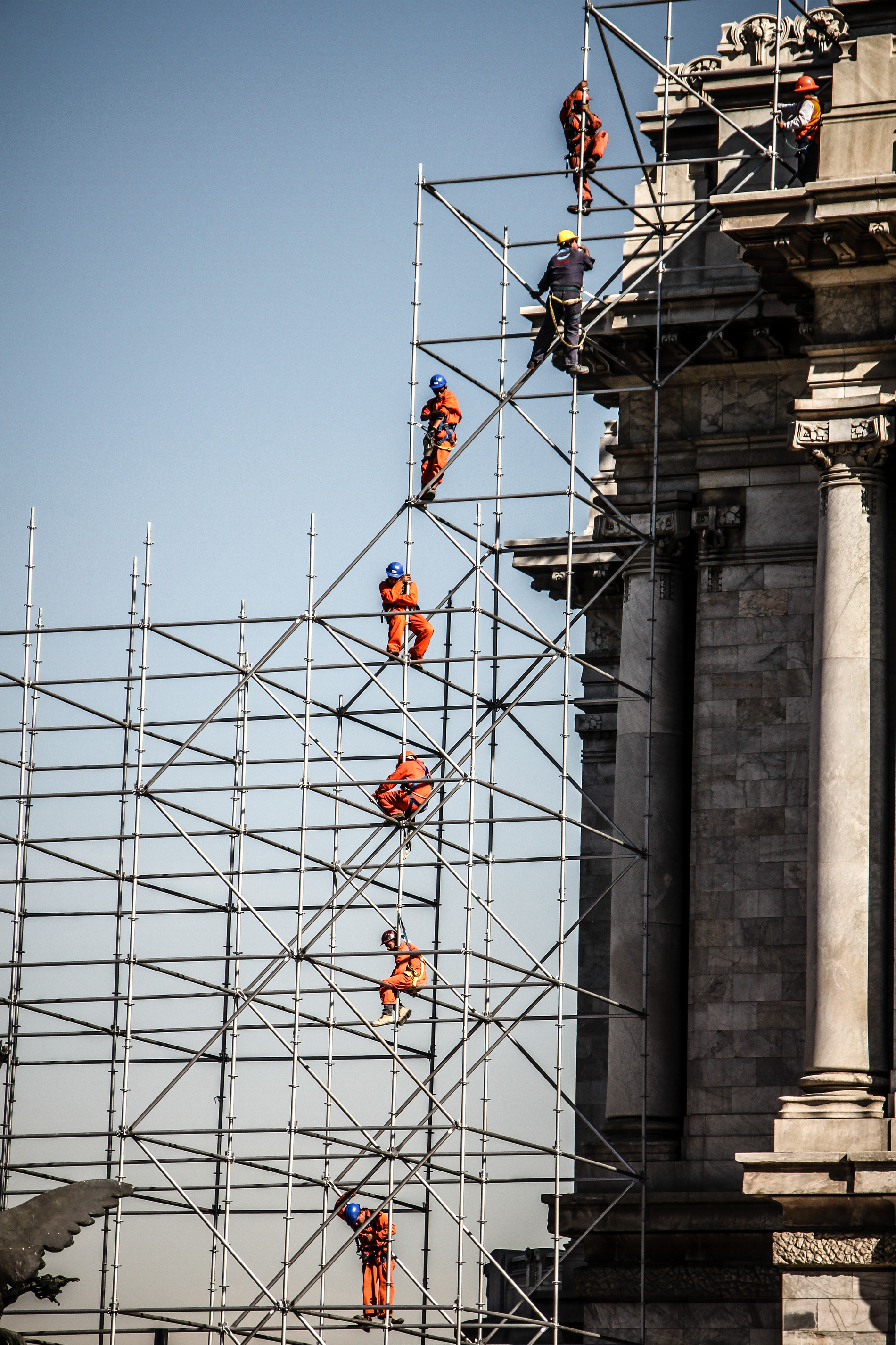 Construction Workers on Tall Scaffolding Renovating Historical Building